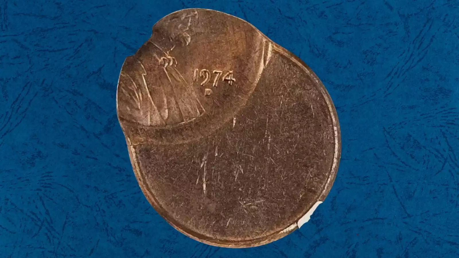 1974 Lincoln penny off-center strike showing crescent-shaped blank area with date still visible on the coin